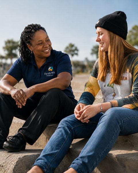 Support worker talking with a teenager outdoors